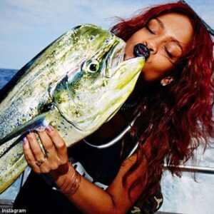 You're the one: Rihanna shared a snap of her kissing a fish on a fishing trip off Honolulu on Friday along with the caption, 'Meet my catch of the day... mr. mahi'