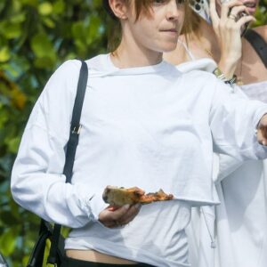Out and about: Emma Watson showcased her natural beauty as she stepped out eating a slice of pizza in Miami on Monday