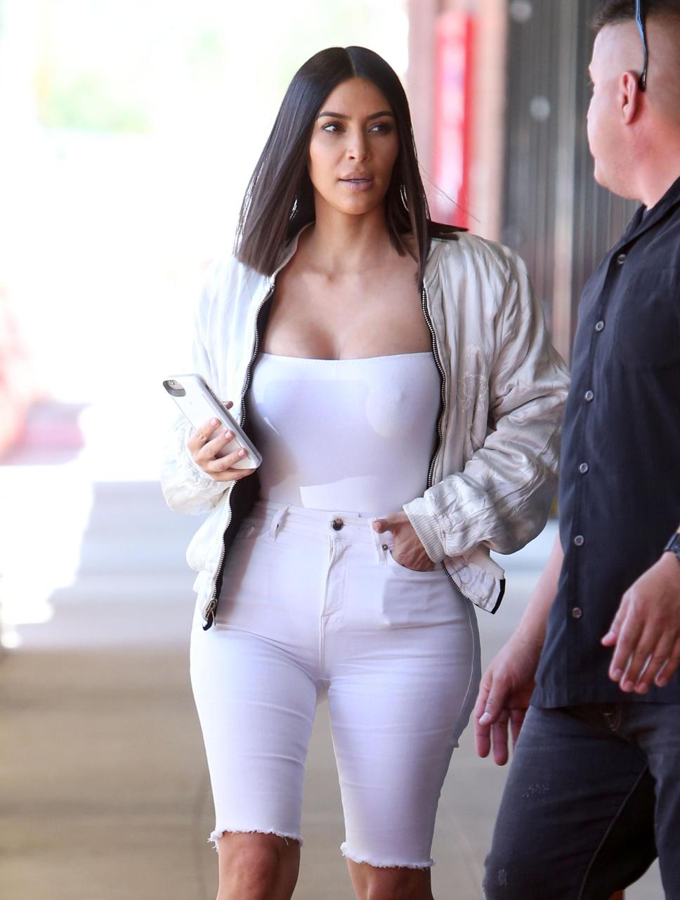 Kim Kardashian ditches the bra as she shows off her busty figure in white vest top | The Sun
